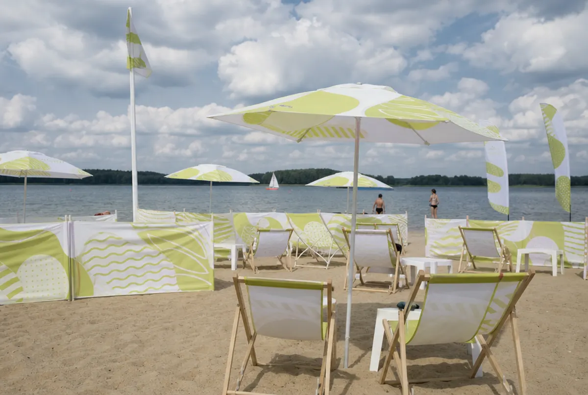 Plaża ośrodka z parasolami, leżakami i parawanami z nadrukiem