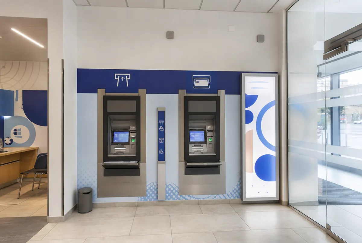 Strefa bankomatów w oddziale banku z oznakowaniem i lightboxem