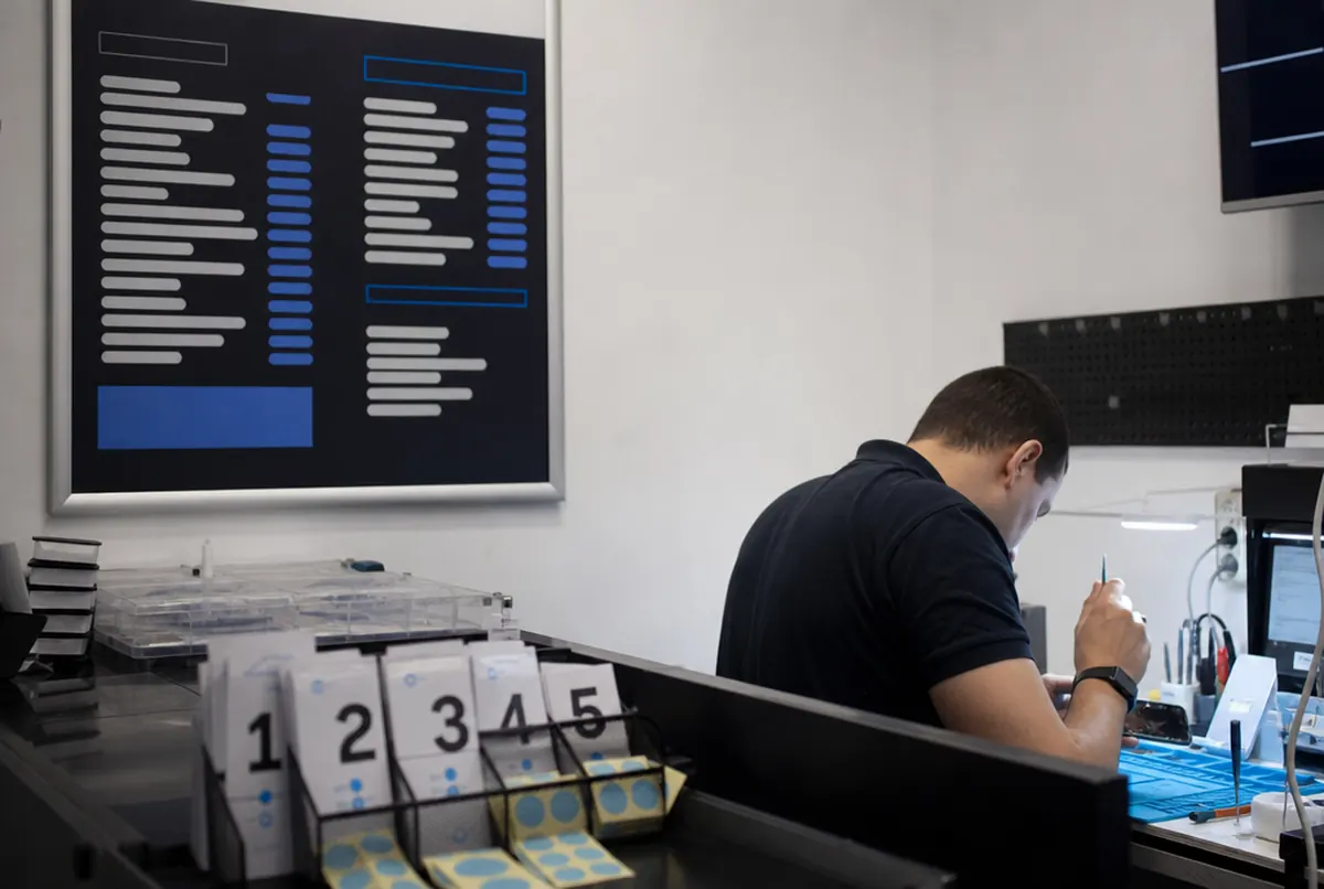 Serwis telefonów w salonie GSM z cennikiem napraw na ścianie