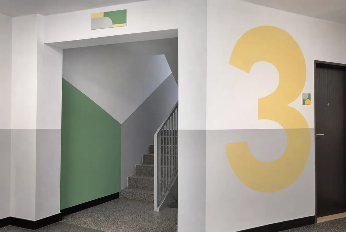 Klatka schodowa bloku z numerami pięter i grafiką