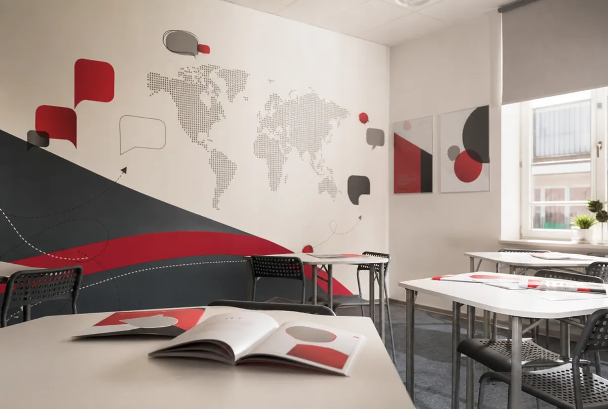 Sala szkoły językowej z grafikami ściennymi i plakatami dydaktycznymi
