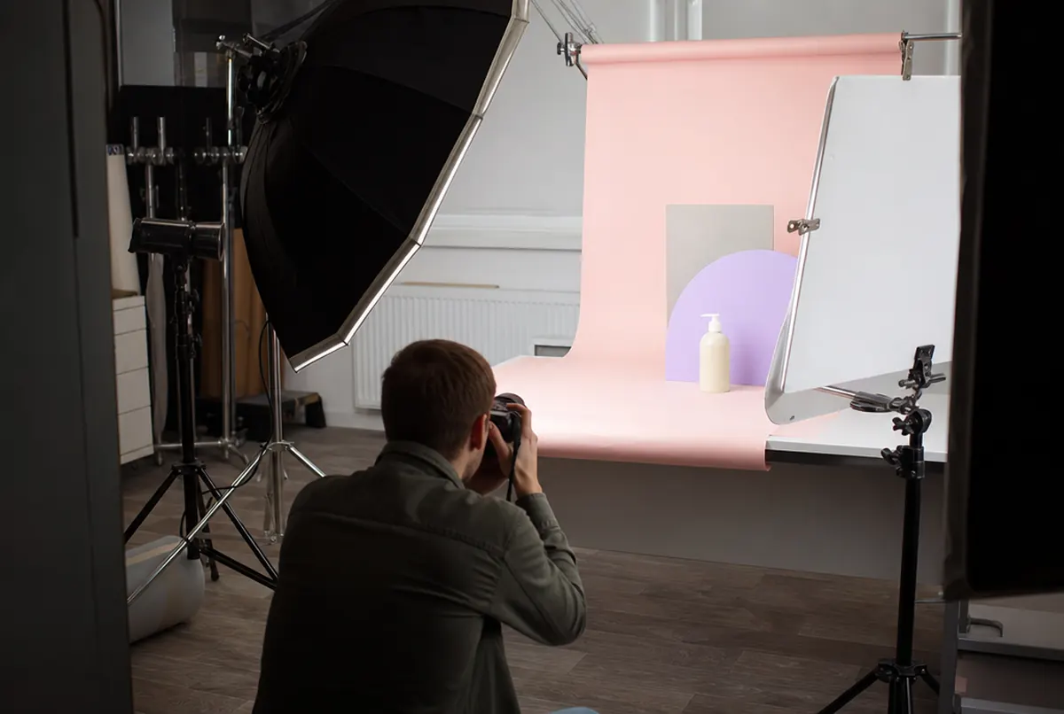 Sesja produktowa w studiu, fotograf tyłem przy softboxach