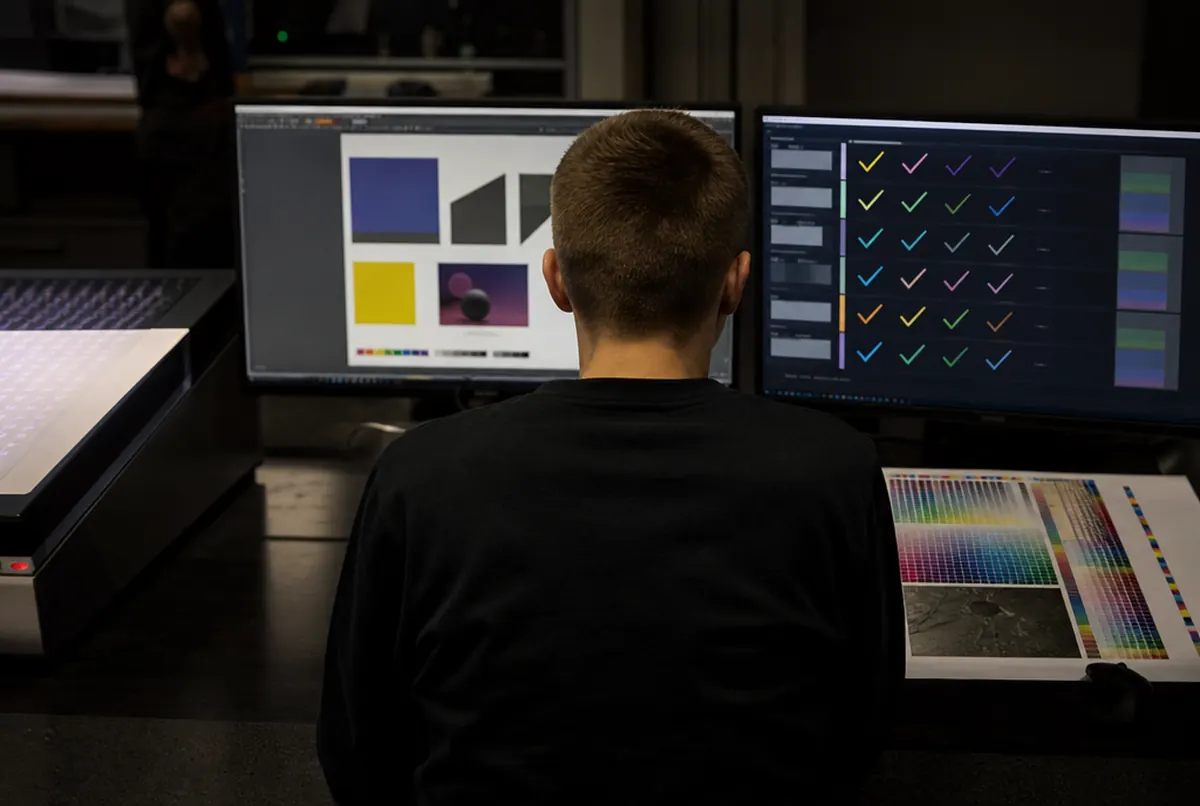 Operator prepressu sprawdza plik na dwóch monitorach