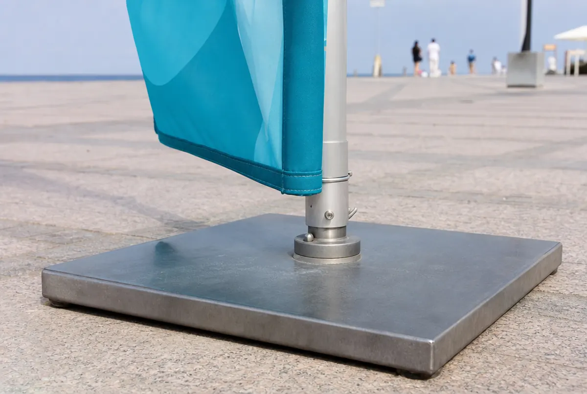 Close-up of a beach flag's steel plate base and the sewn pole sleeve of the flag