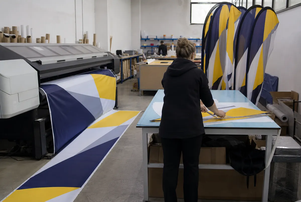 Sublimation printing and cutting of sail-shaped beach flags in the workshop