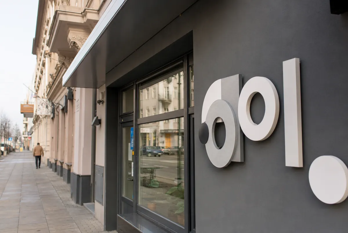 CNC-cut dimensional shapes from PVC and composite mounted on a dark shop facade