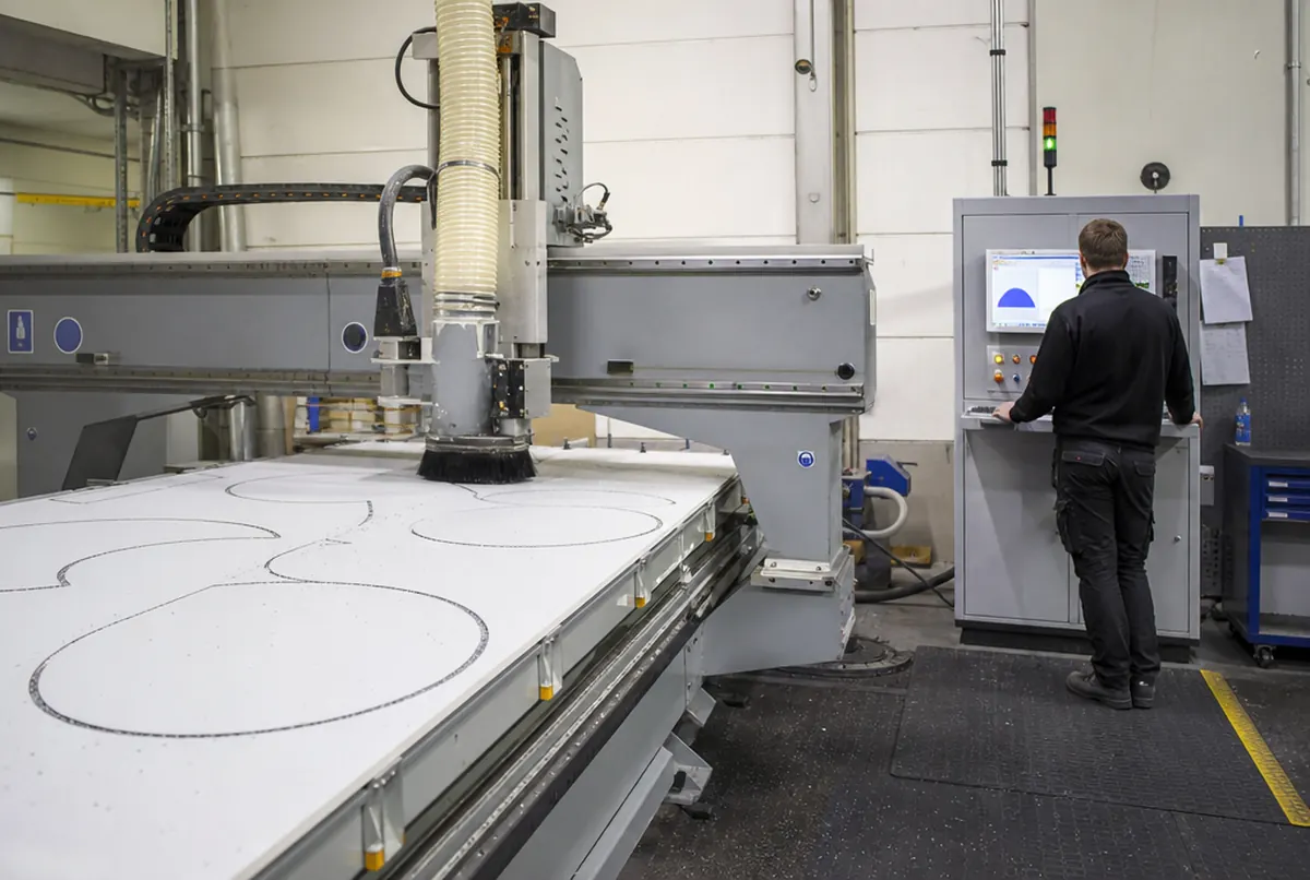 CNC router cutting shapes from aluminium composite with the operator at the controls