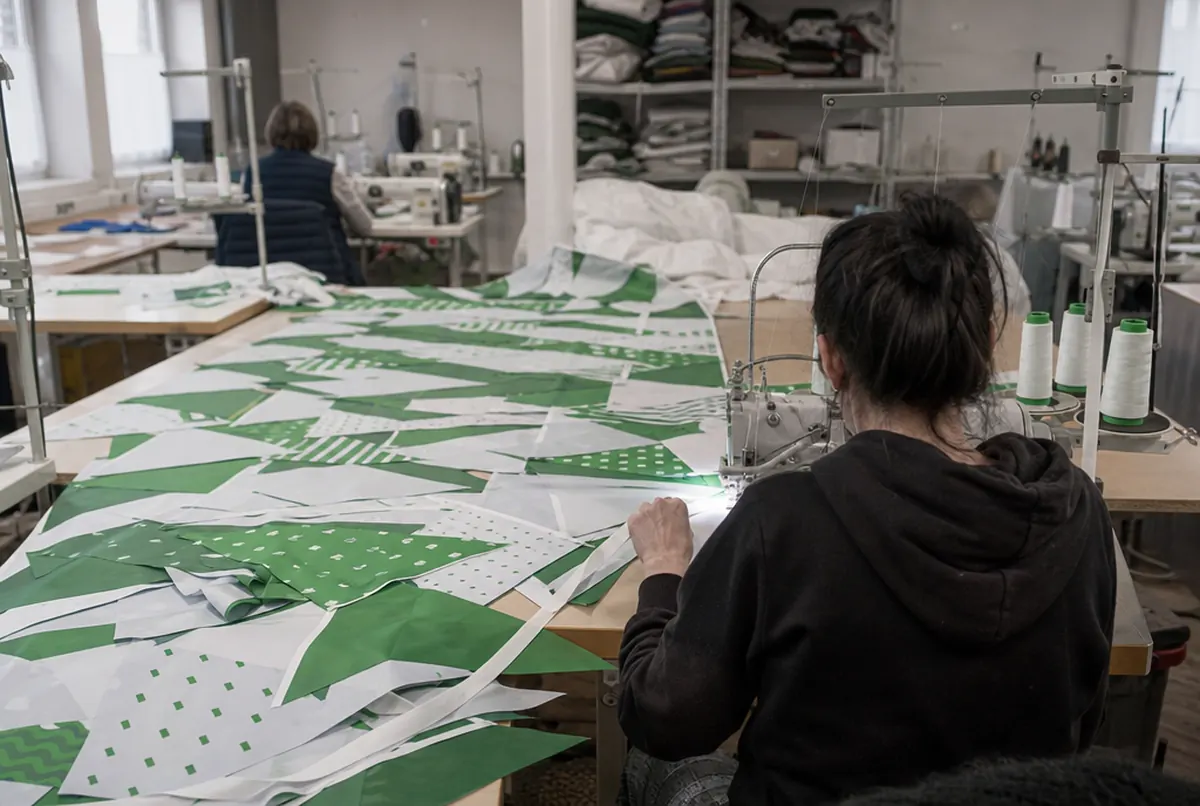 Cosido de banderines impresos a la cinta en una máquina industrial