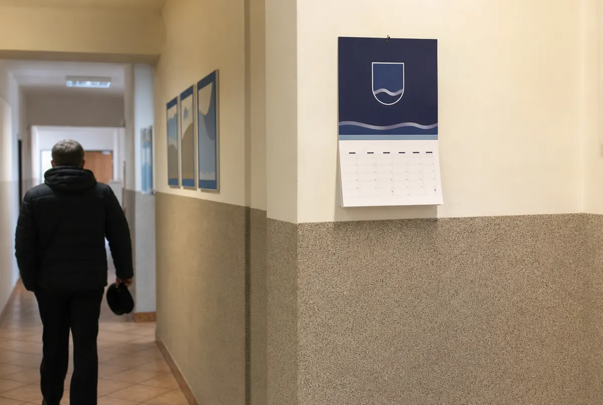 Einblattkalender mit Kopfteil und einem Kalendarium im Flur eines Rathauses