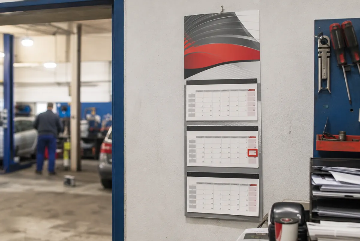 Dreimonatskalender mit Kopfteil und Datumsschieber im Büro einer Werkstatt