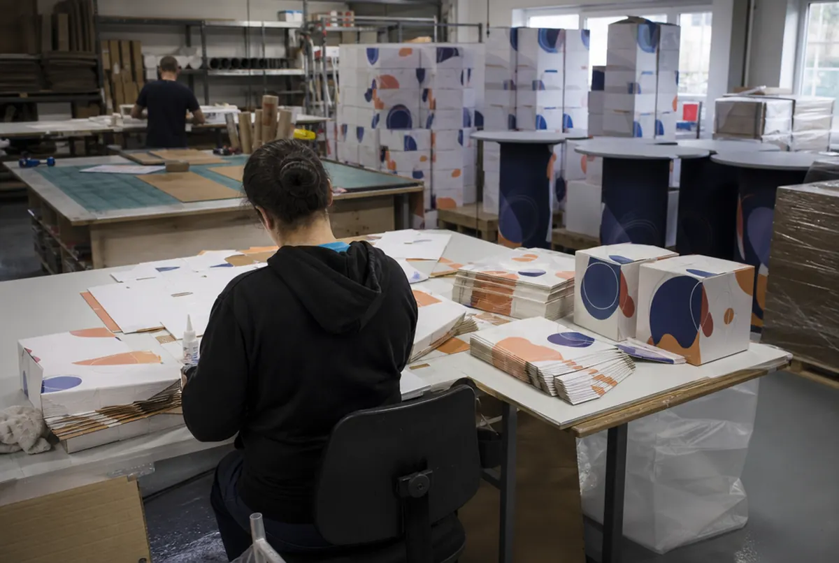 Plegado de troqueles impresos en cubos en la mesa de montaje del taller
