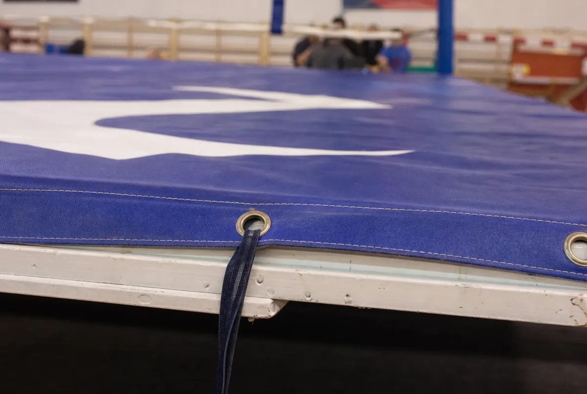 Close-up of a ring mat cover's stitched edge with eyelets and a tie strap