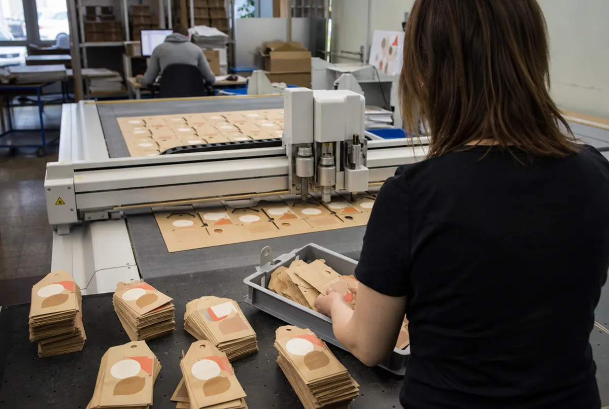 Cutting shaped hang tags from a kraft board sheet on a cutting plotter