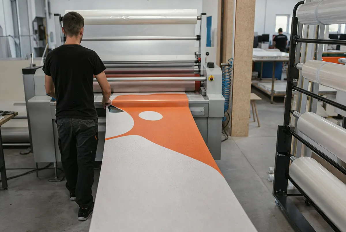 Kaschieren der bedruckten Bodenfolie mit Antirutschlaminat in der Druckerei