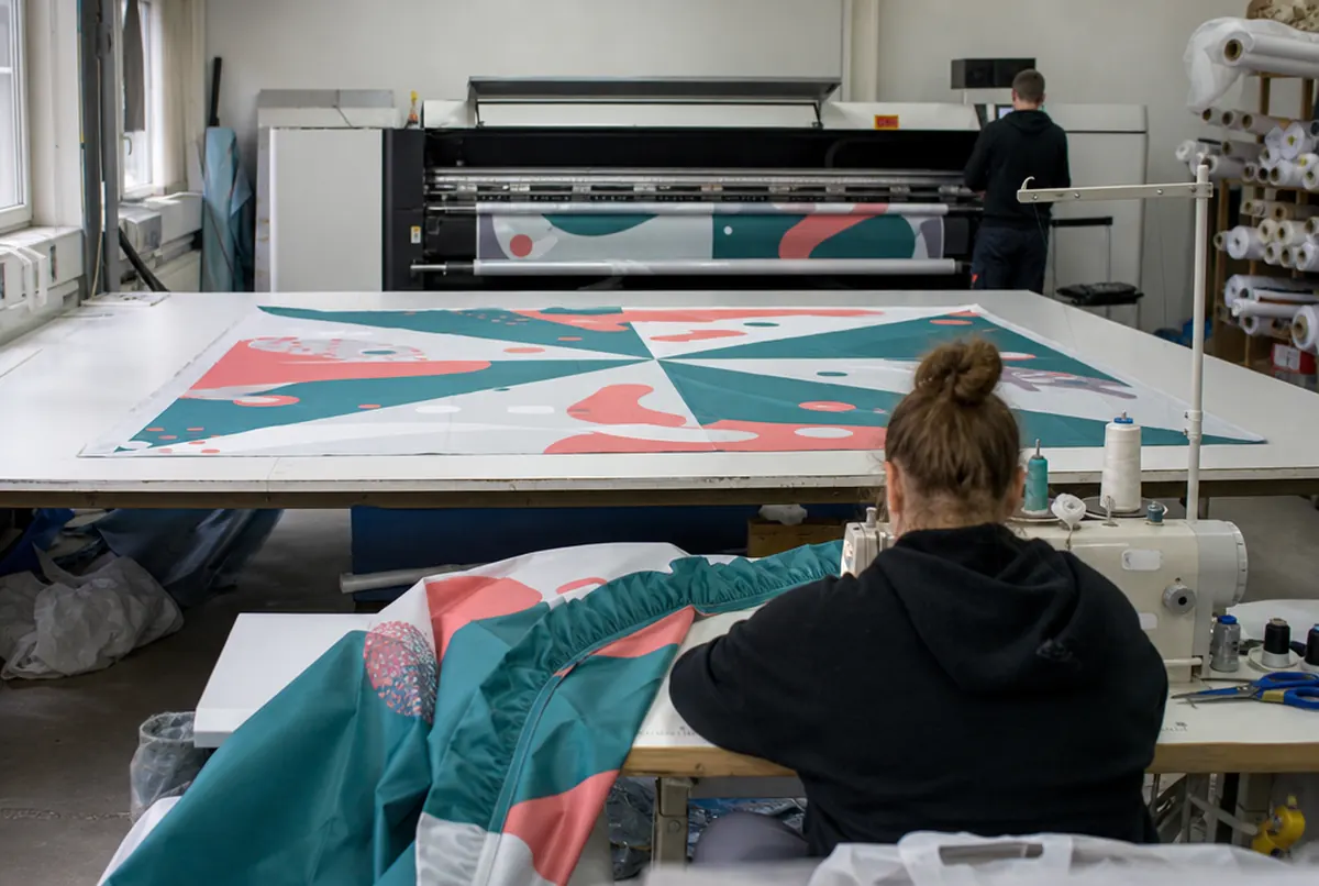 Cosido de la cubierta estampada de una carpa en el taller textil