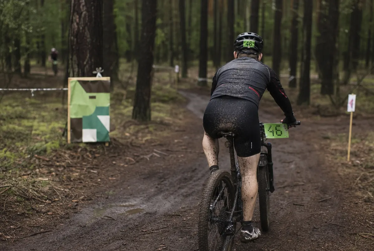 Startnummer an Lenker und Helm eines Fahrers bei einem MTB-Rennen im Wald