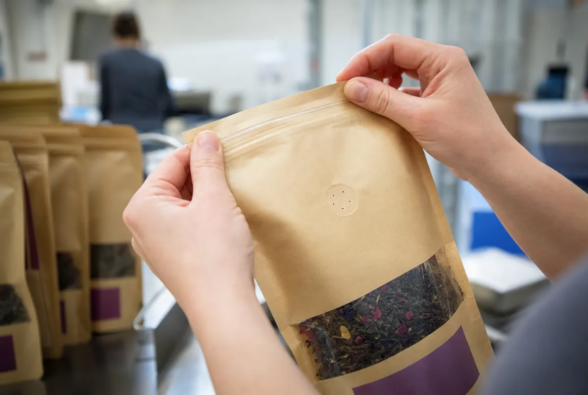 Primer plano de una bolsa kraft con zip, ventana y muesca de apertura