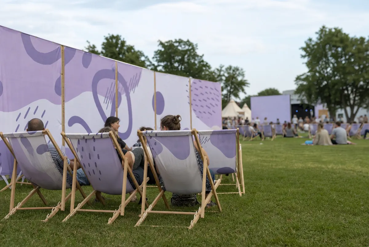 Tumbonas y cortavientos estampados en la zona chill-out de un festival