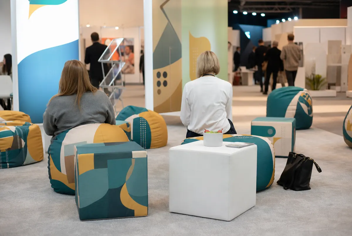 Bedruckte Sitzsäcke und Sitzwürfel in der Lounge eines Messestands