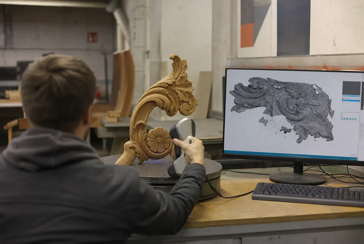 Technicien numérisant un ornement en bois au scanner 3D portable